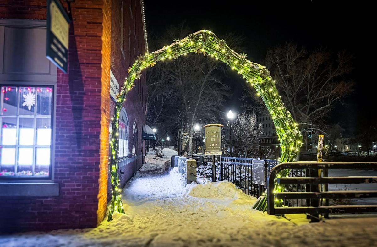 Arch art installation lit up at night in downtown Dover