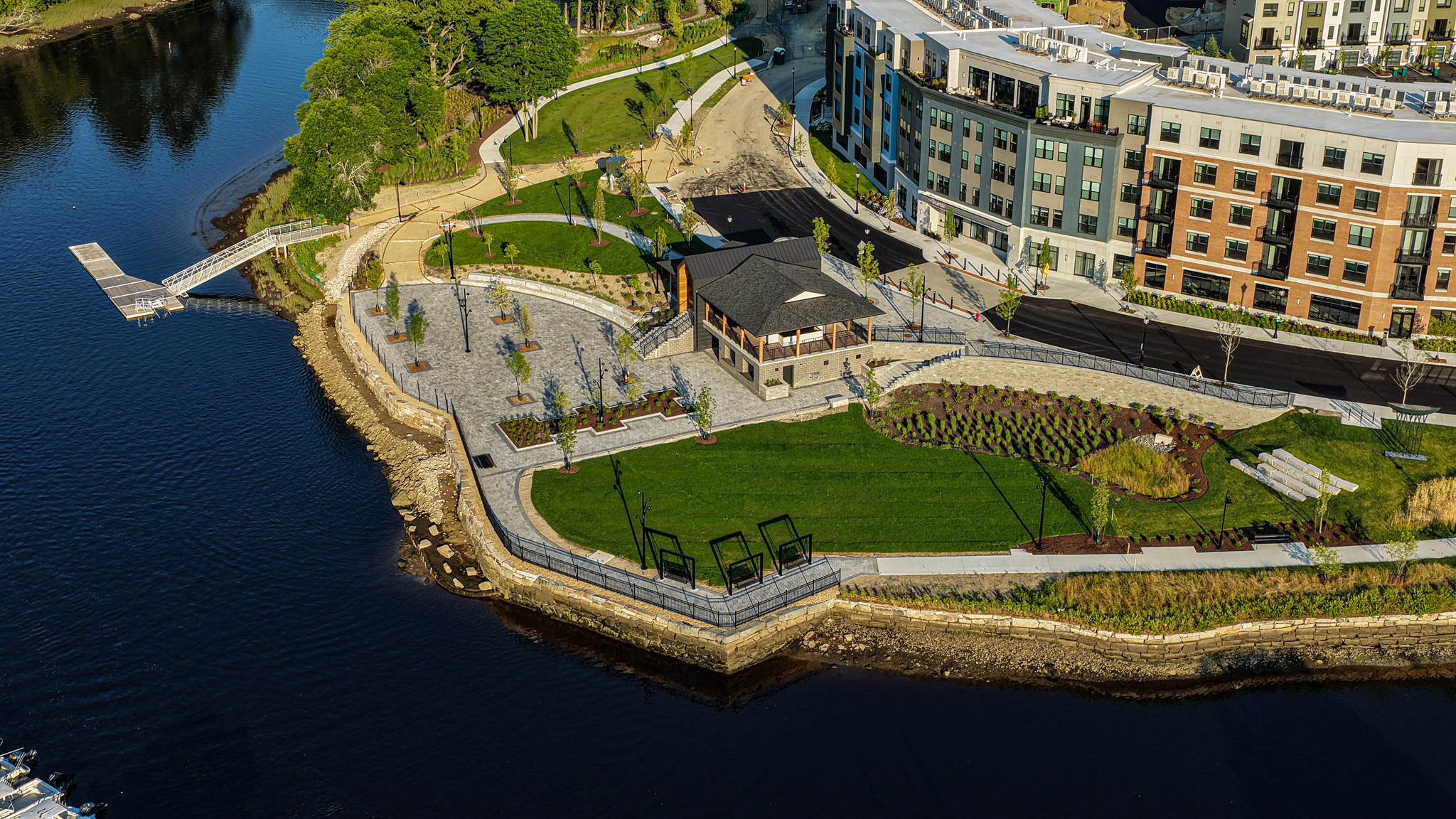 Waterfront Nebi Park nearly complete in June 2026 An aerial view of the Cochecho Waterfront Development project, showing the buildings, Nebi Park, the Pavilion, sports dock and river